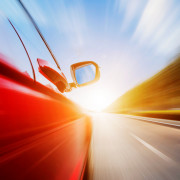 Car speeding down sunlit highway