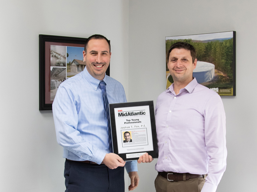 Justin Mendinsky presents the ENR Top Young Professionals plaque to Josh Fox