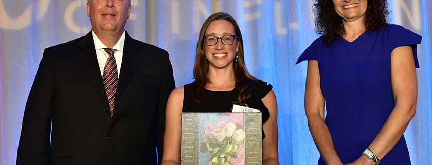 Erin Letavic receives a plaque recognizing her as a Woman of Influence