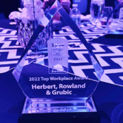 A crystal award for HRG as one of 2022's Top Work Places in Pittsburgh is bathed in purple light on a table at the ceremony