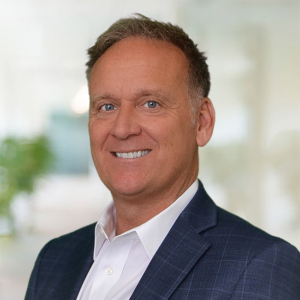 Jeff Garrigan wearing a white button-down shirt and dark suit coat