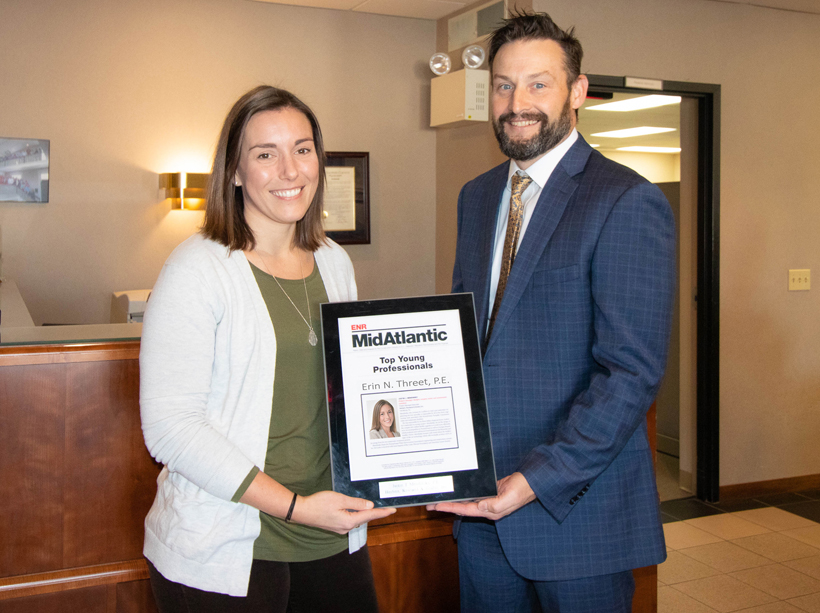 Erin Threet receives a plaque from company president Jason Fralick