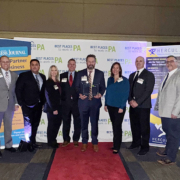 The HRG team holds their award on the red carpet at the Best Places to Work in PA ceremony on December 12, 2024.