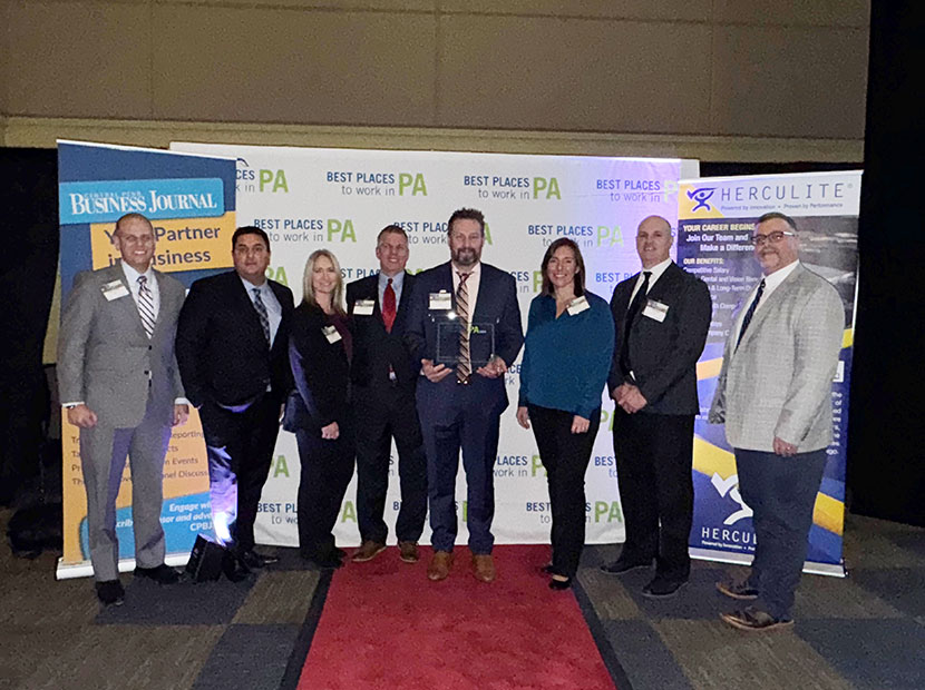 The HRG team holds their award on the red carpet at the Best Places to Work in PA ceremony on December 12, 2024.