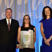 Erin Letavic receives a plaque recognizing her as a Woman of Influence