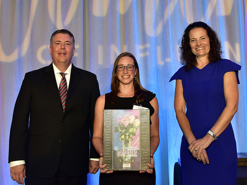 Erin Letavic receives a plaque recognizing her as a Woman of Influence