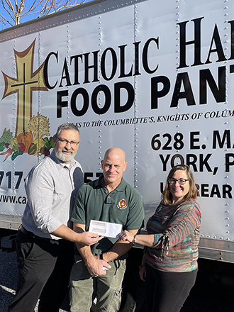Tim Staub presents a check to the Catholic Harvest Food Pantry