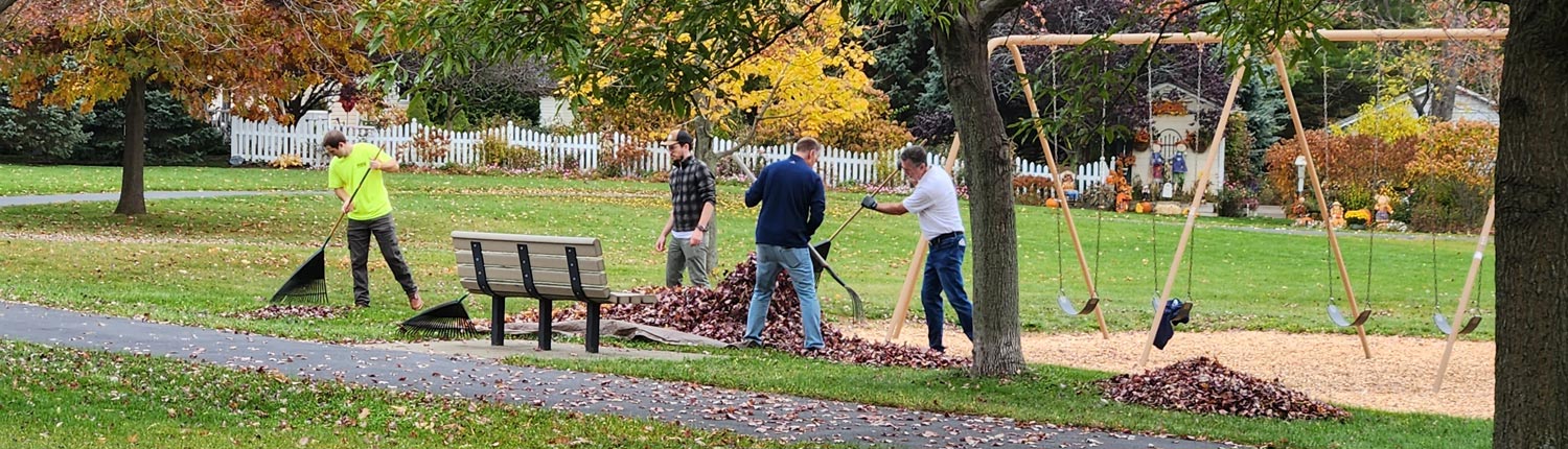 State College team members clean up leaves in a park