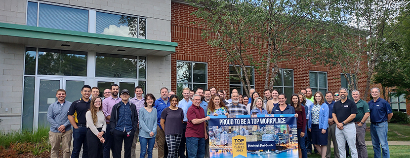 HRG's team holds a banner celebrating their inclusion on the 2023 list of Pittsburgh's Top Workplaces