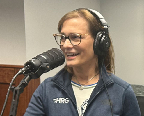 Melissa Rohland smiles and talks into a microphone as she records a podcast on smart water technology and digital twins