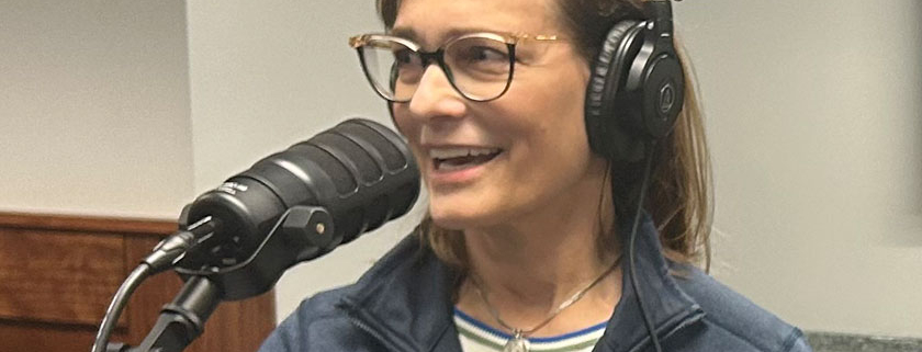 Melissa Rohland smiles and talks into a microphone as she records a podcast on smart water technology and digital twins