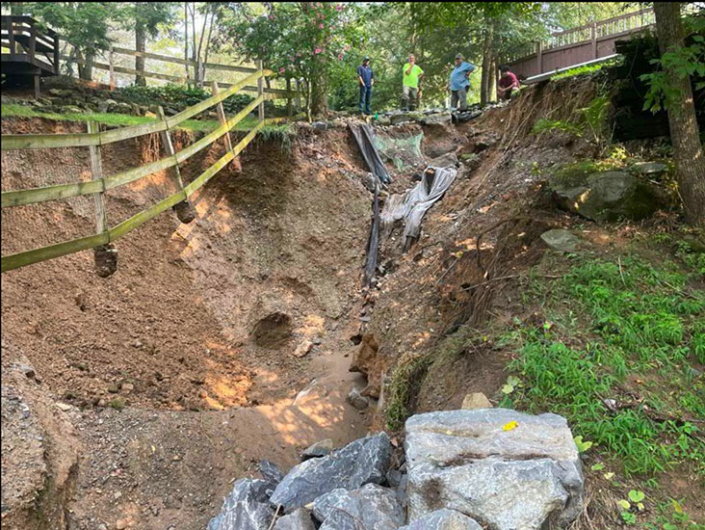Palmer-Township-Flash-Flood-Advice-Municipal-Reporter Township staff and their engineer examine a crater opened up by flash flood waterss