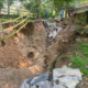 Township staff and their engineer examine a crater opened up by flash flood waterss
